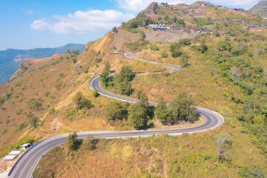 Aerial View Of Cars Driving On Curved, Zigzag Curve Road Or Street On Mountain Hill With Green Natural Forest Trees In Rural Area Of Nan, Thailand. Transportation.