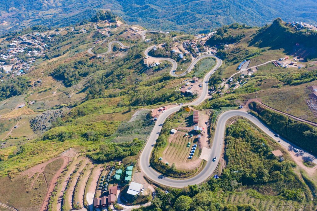 Aerial View Of Cars Driving On Curved, Zigzag Curve Road Or Street On Mountain Hill With Green Natural Forest Trees In Rural Area Of Phu Tub Berk, Phetchabun, Thailand.
